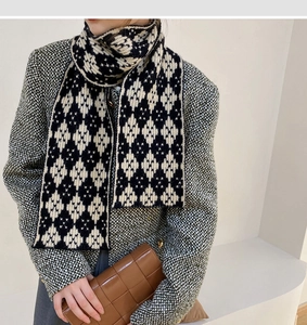 Detail of a thick knitted scarf with black and white geometric patterns and textures