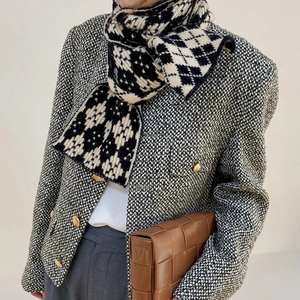 Detail of black and white knitted scarf with floral patterns and diamond textures