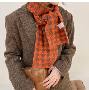 Detail shot of orange and brown houndstooth knit scarf with thick textured pattern