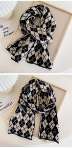 Detail of soft black and white argyle knit scarf texture with thick warm fabric