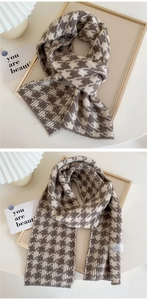 Detail of soft knit scarf featuring a classic brown and cream houndstooth pattern texture