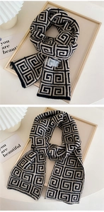 Detail of a thick knitted scarf with black and white Greek key geometric patterns