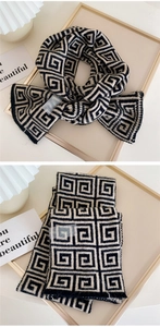 Close-up of geometric knit scarf texture with washing label and fringe details