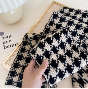 Thick black and white houndstooth knit scarf showing soft texture and warm winter style