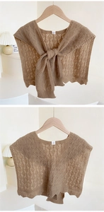 Detail of coffee brown knit shawl featuring diamond hollow pattern and scalloped edges
