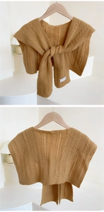 Close-up of camel knit shawl with hollow openwork texture and knotted tie detailing