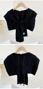 Detailed view of black crochet knit shawl with knot design showing front and back texture