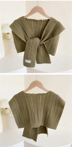 Detailed knit texture of grass green shawl with cable patterns and openwork crochet design