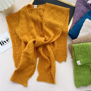 Knitted hollow-out shawl wrap in various colors for women on a white textured background