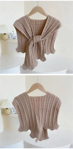 Detail of light coffee knitted shawl featuring classic cable texture and wavy edges