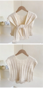 Detail of cream cable knit shawl featuring intricate chunky textures and wavy scalloped edges