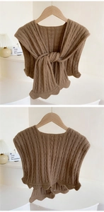 Detail of coffee brown cable knit shawl with wave edges and thick textured weave