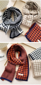Detail of knitted long scarf with houndstooth and herringbone patterns and label