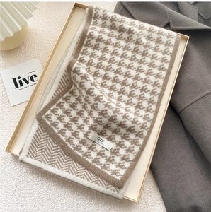 Detailed knit texture of houndstooth scarf with elegant brand woven label tag