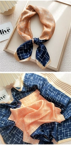 Detail of 70cm square silk scarf with navy and peach geometric grid and satin finish