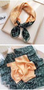 Detail of silk-texture square scarf featuring orange and dark green grid patterns