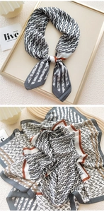 Detail of geometric letter A print silk scarf with caramel border and soft texture