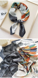 Close-up of artistic silk scarf with vibrant feather prints and hand-lettered patterns