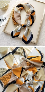 Detailed macro view of geometric pattern silk scarf with satin texture and vibrant orange tones