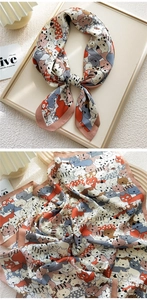Detailed close-up of a square silk scarf with cute cartoon cat patterns in soft colors
