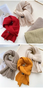 Close-up of thick ribbed knit scarves in multiple colors with stylish sewn-on labels