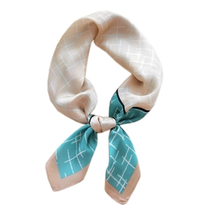 Elegant teal and beige grid silk scarf tied in a knot on a clean white background