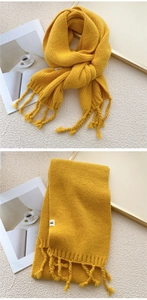 Detail of chunky yellow knit scarf showing thick tassels and woven texture finish