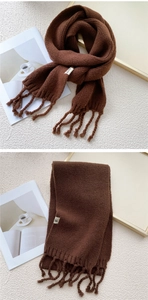 Detail of thick dark brown knit scarf showing premium wool texture and tassel fringe
