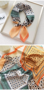 Detailed pattern view of an orange and green floral geometric satin scarf for women