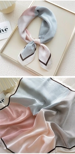 Macro detail of a striped silk scarf in pastel tones with black contrast edge stitching