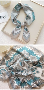 Detailed close-up of paisley pattern silk scarf with soft blue and beige textures
