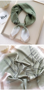 Detail of grey-green silk scarf with black line patterns and elegant satin texture
