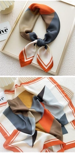 Macro shot of geometric color block silk scarf with orange and grey patchwork pattern