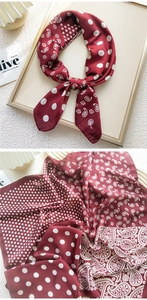 Close-up of burgundy silk scarf with elegant paisley patterns and white polka dots