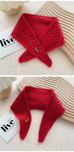 Detail of red cable knit scarf showing thick texture and decorative wooden button closure