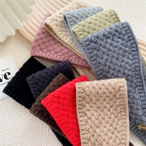 Chunky knit button scarf for women in multiple colors on a textured wooden tray