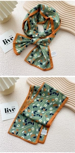Detail of skinny silk scarf with green floral pattern and orange border for neck decoration