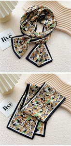 Detailed view of narrow silk scarf with abstract geometric patterns and smooth satin texture