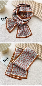 Detail of light blue silk scarf with red daisy patterns and dark brown border trim