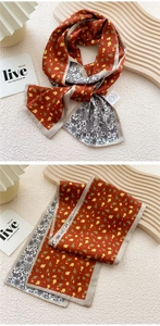Detail of double-sided twilly silk scarf with orange floral pattern and mandala texture