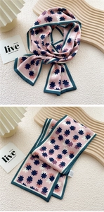 Detail of pink floral skinny scarf with dark green borders and daisy pattern texture
