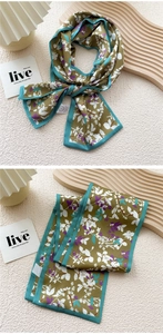 Detail of olive green floral silk scarf with lavender trim on a wooden tray