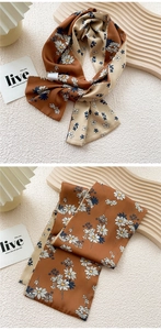 Detail of a dual-color brown and beige skinny silk scarf featuring delicate daisy prints