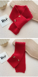Detail of red chunky knit scarf showing thick texture and dark brown button closure