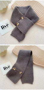 Macro shot of dark grey knit muffler with vintage amber buttons and ribbed texture detail