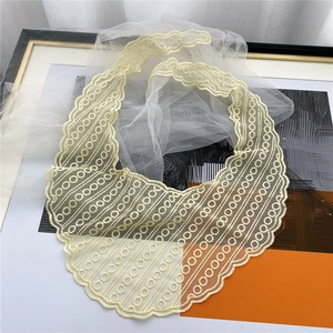 Close-up of cream lace scarf showing intricate embroidery and scalloped edge detail