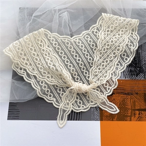 Detailed close-up of cream lace scarf with hollow circle embroidery and scalloped edges