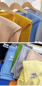 Close-up of multicolored knit shawls showing the brand label and soft cashmere texture