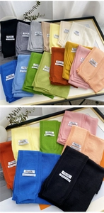 Close-up of knit shawls in multiple colors with cashmere fabric labels