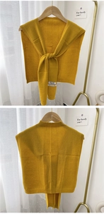 Detail view of yellow cashmere knit shawl showing fabric texture and brand label tags